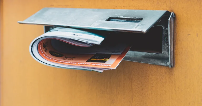 Brievenbus in een houten voordeur met post die er half uit steekt