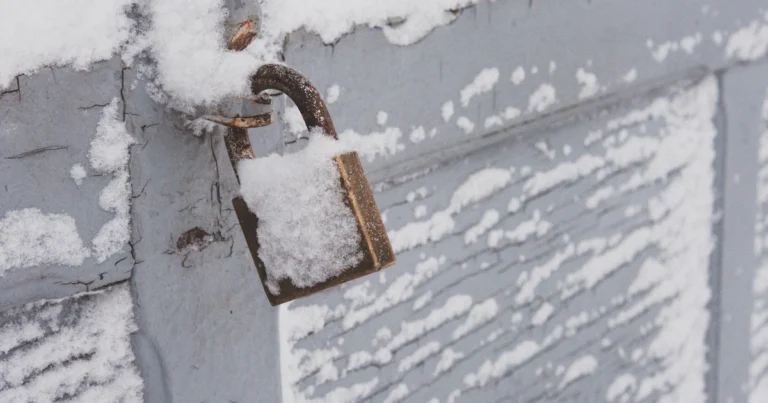 Hangslot op een houten deur, bedekt met sneeuw en vorst